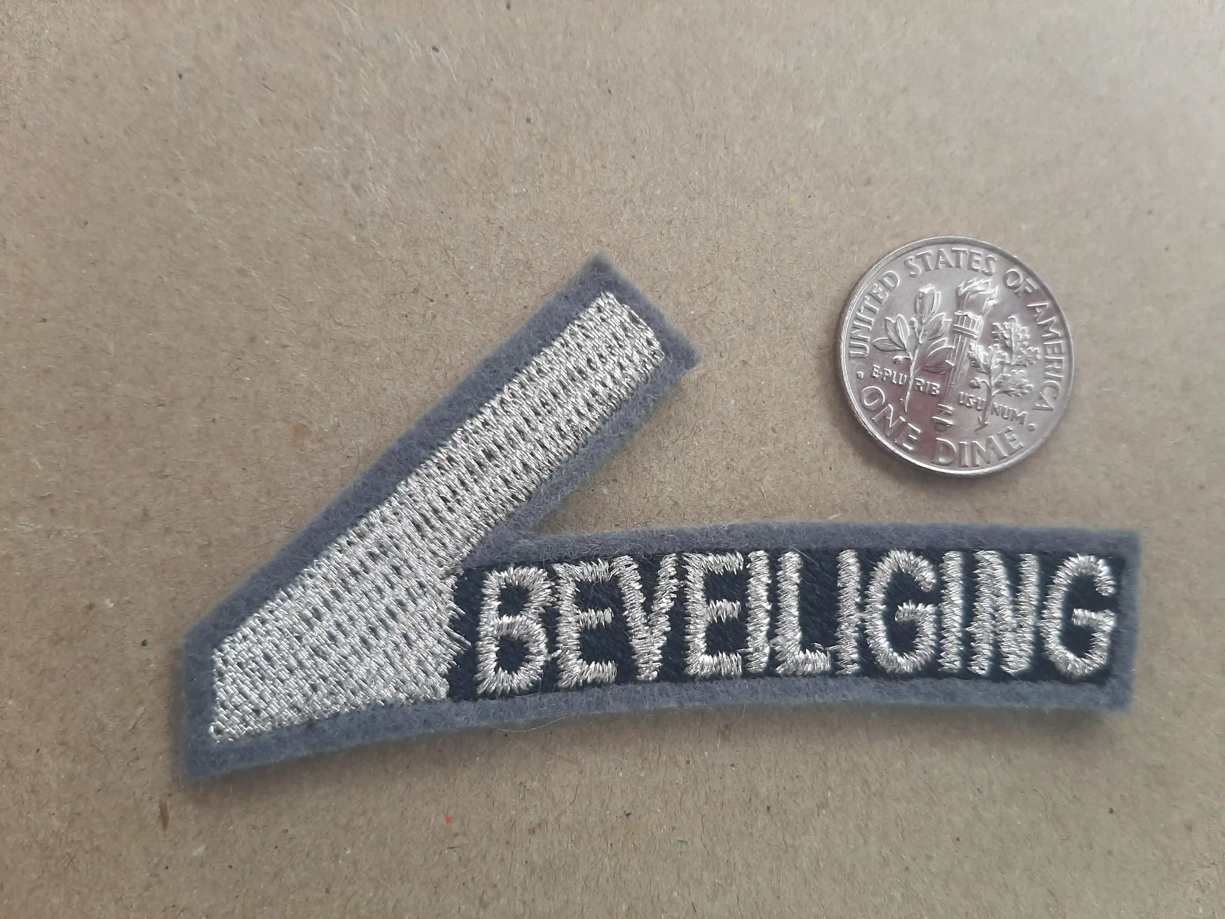 Dutch Ministry of Justice and Security approved the V shaped design containing Gold METALLIC embroidery thread that is malleable and tough. Marvel at this Beveiliging Security_Protection
